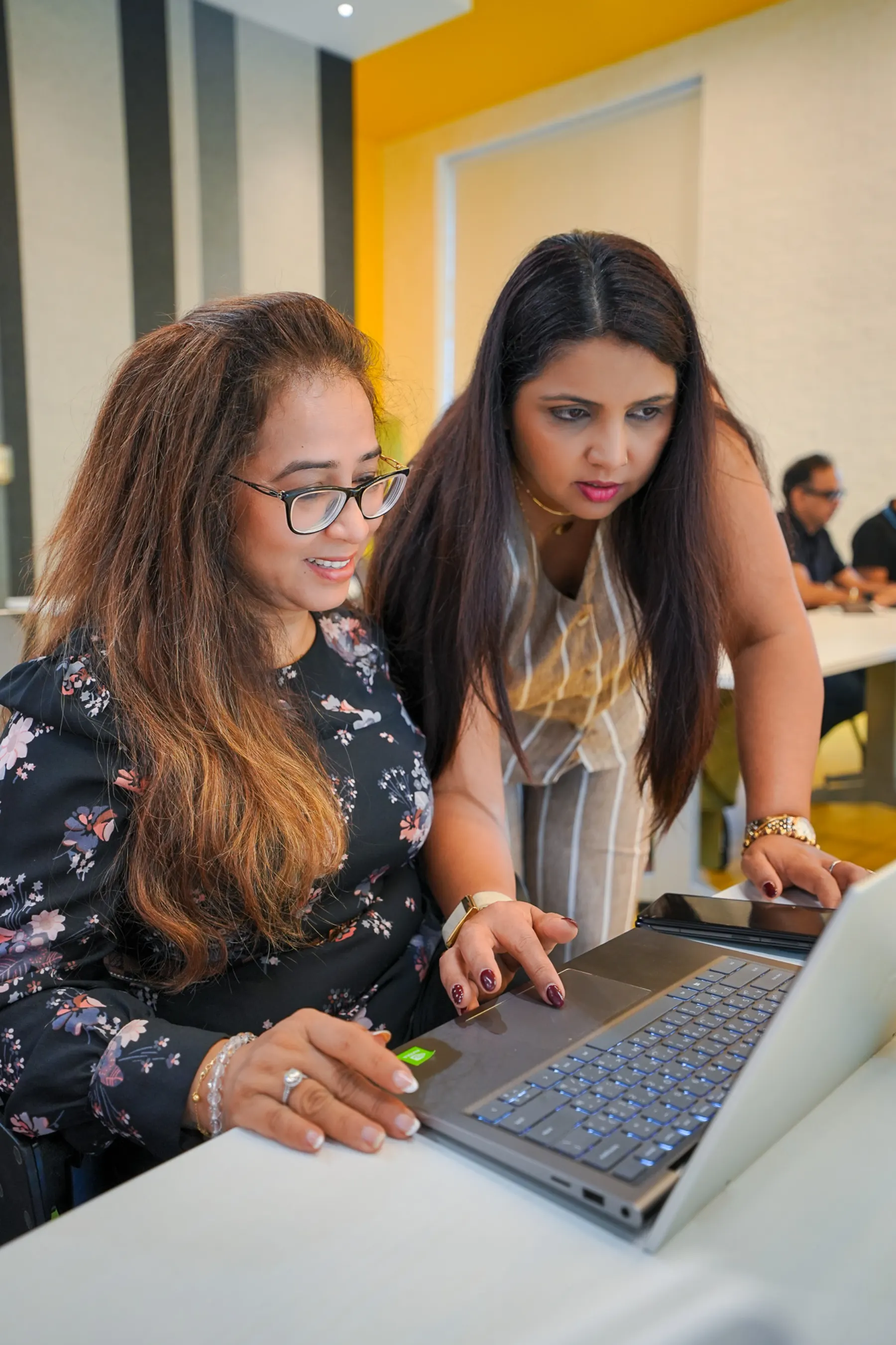 A facilitator helping a participant set up Claude Code on her laptop