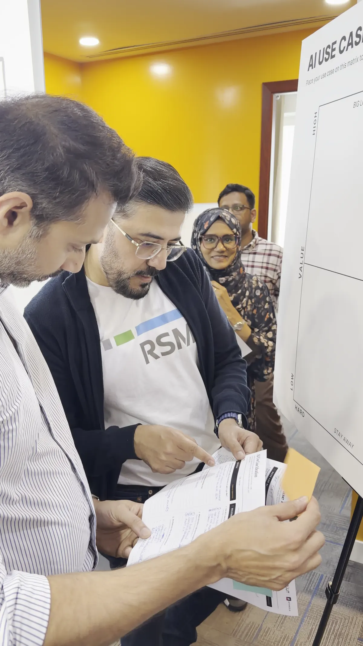Two professionals reviewing a filled-in AI use-case canvas