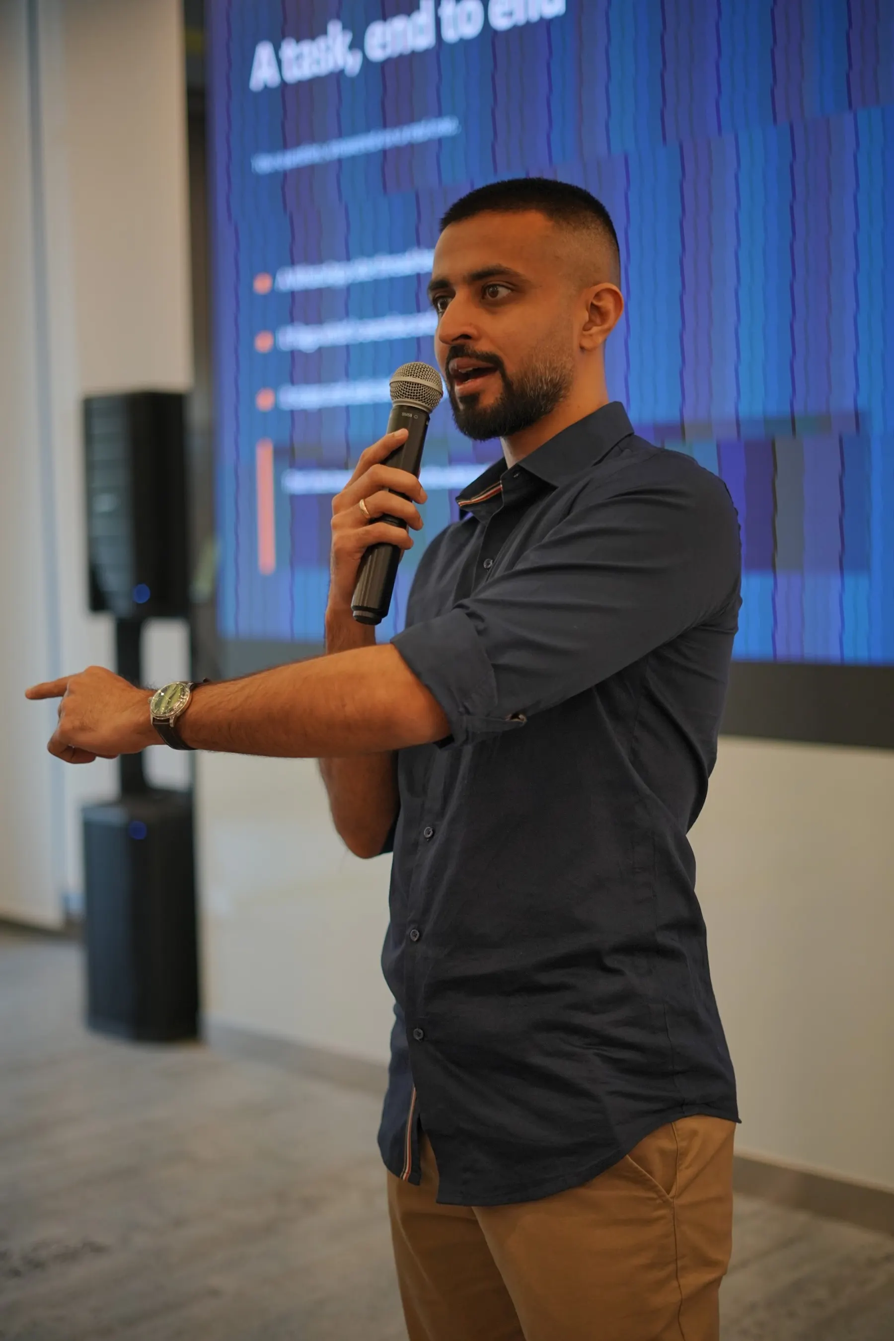 Presenter pointing to a slide about completing a task end to end